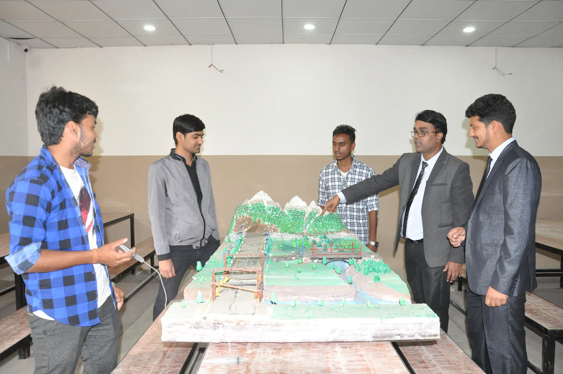 Engineering students presenting and discussing a detailed civil project model