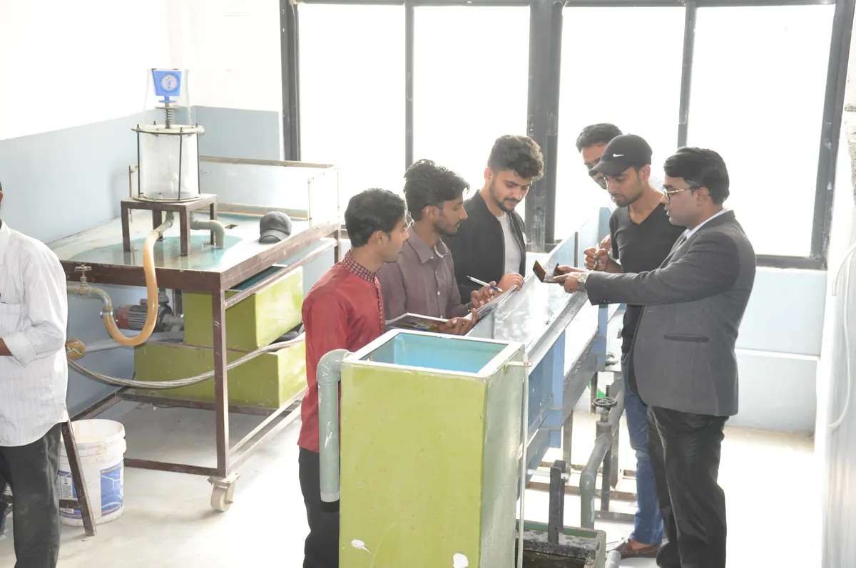 An instructor guiding engineering students during practical work
