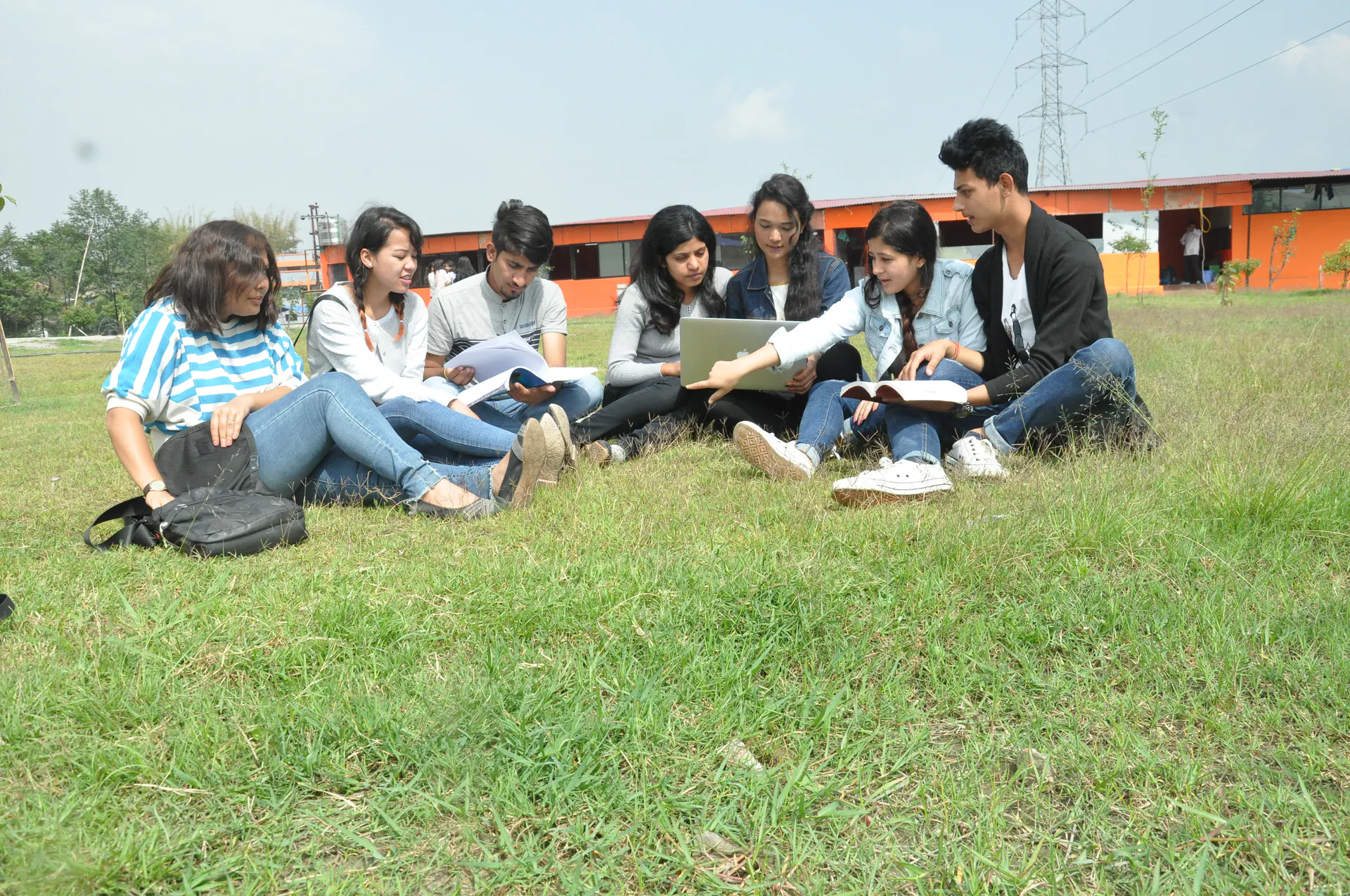 A group of ICE students studying together outdoors on the campus grounds
