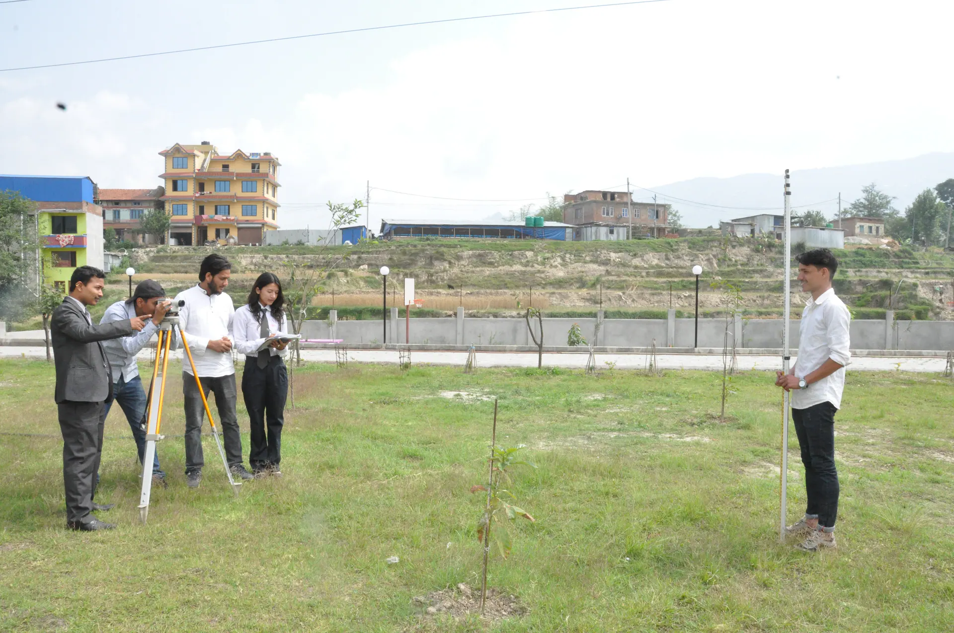 Civil engineering students practising with survey equipment on the campus grounds