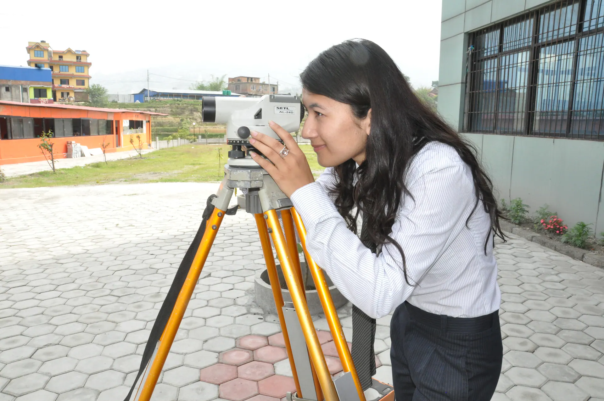 A civil engineering student reading through a survey instrument during field practice