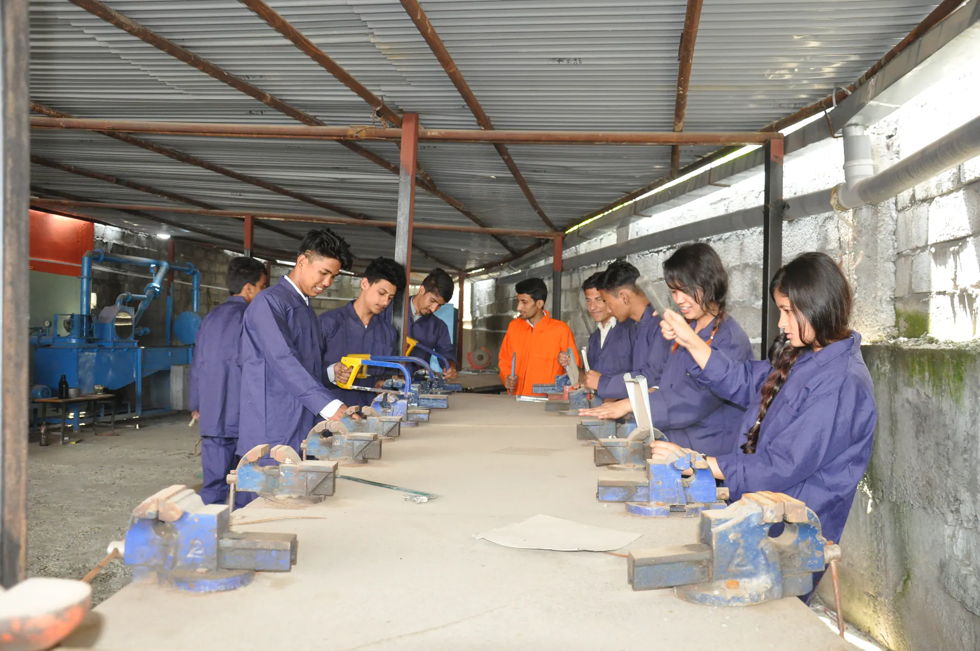 Students working at benches in an engineering workshop