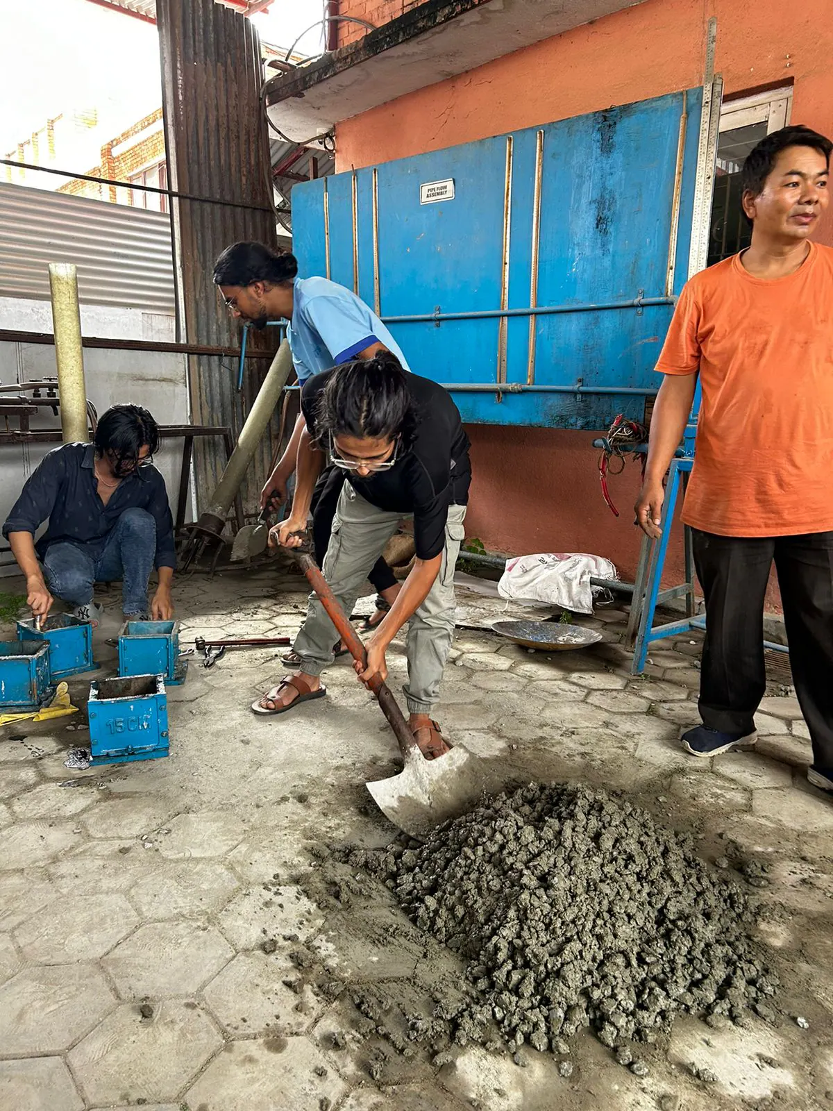 Instructor offering benchwork training guidance to engineering students in workshop